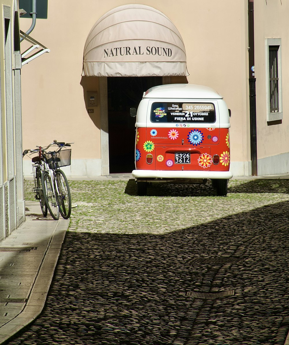 a red and white bus parked in front of a building