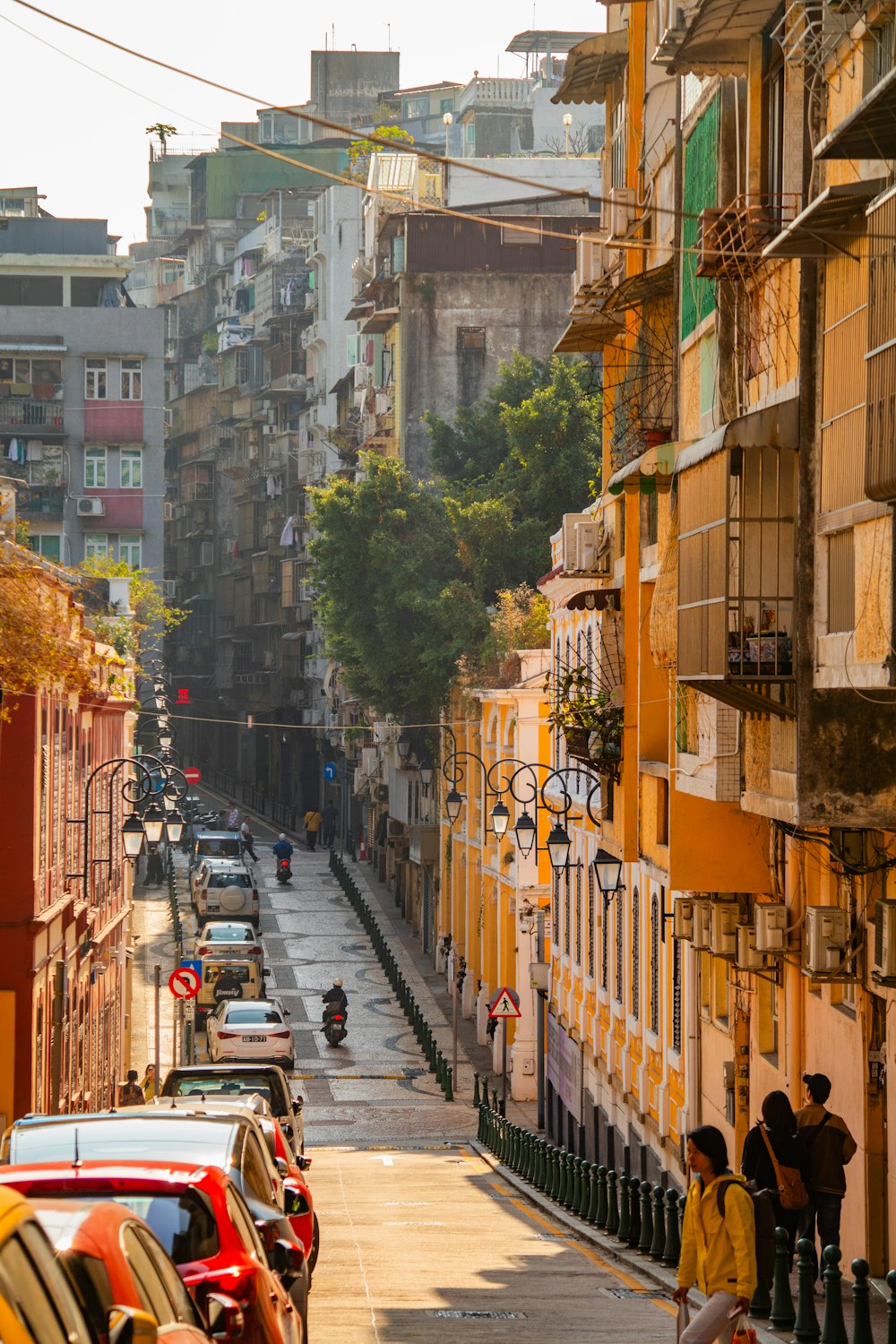 a group of people walking down a street next to tall buildings