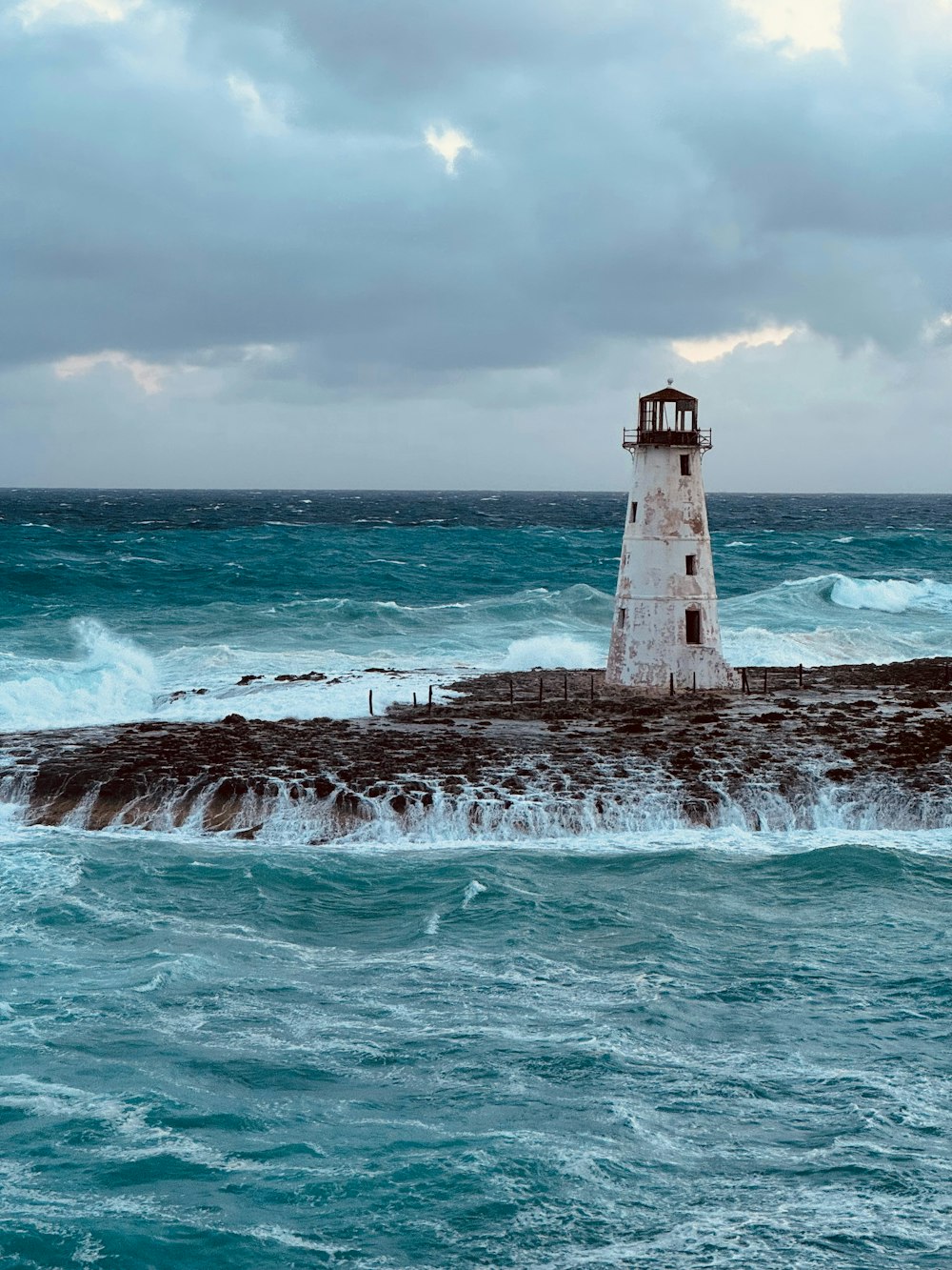 a light house sitting on top of a rock next to the ocean