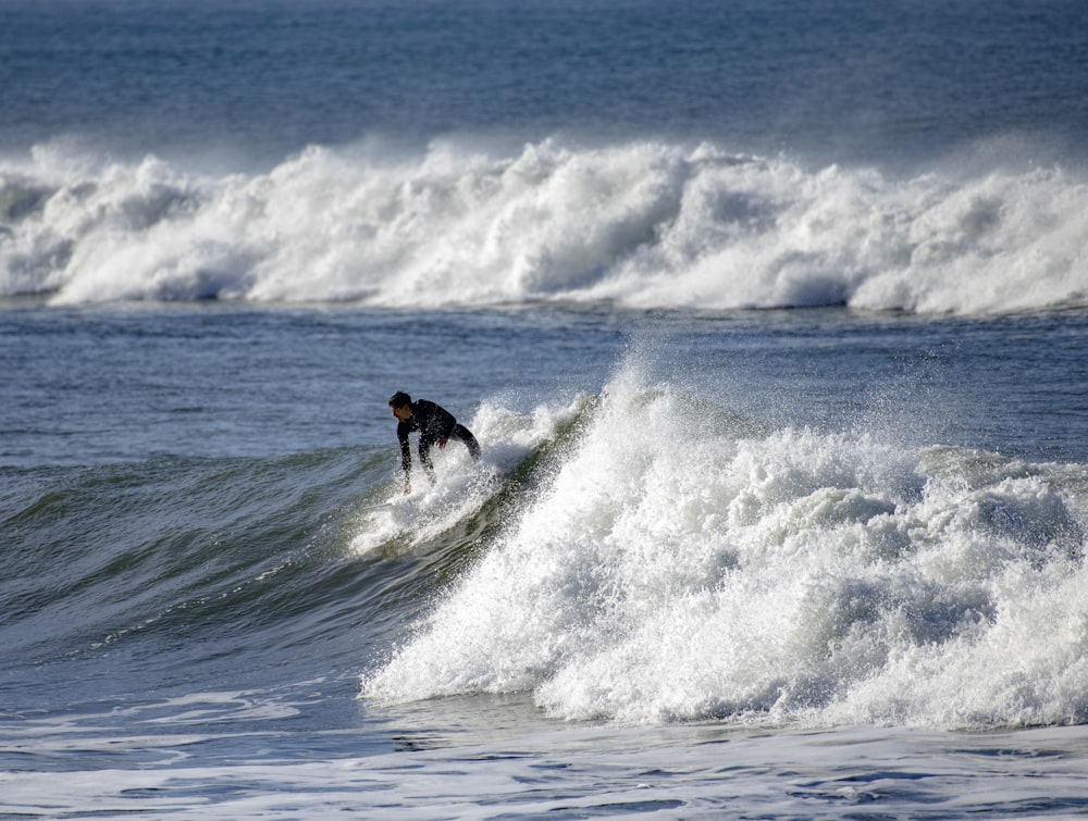 a man riding a wave on top of a surfboard