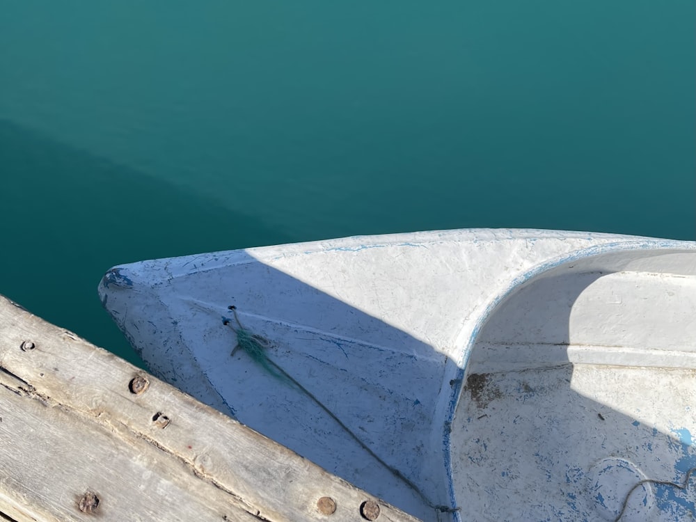 a boat sitting on top of a wooden dock next to a body of water