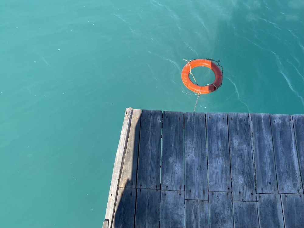 ein orangefarbener Rettungsring, der in einem Gewässer schwimmt