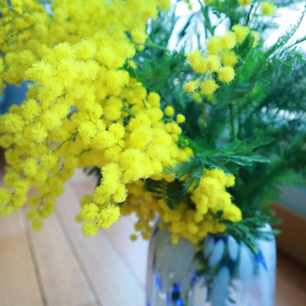 a vase filled with yellow flowers on top of a wooden table