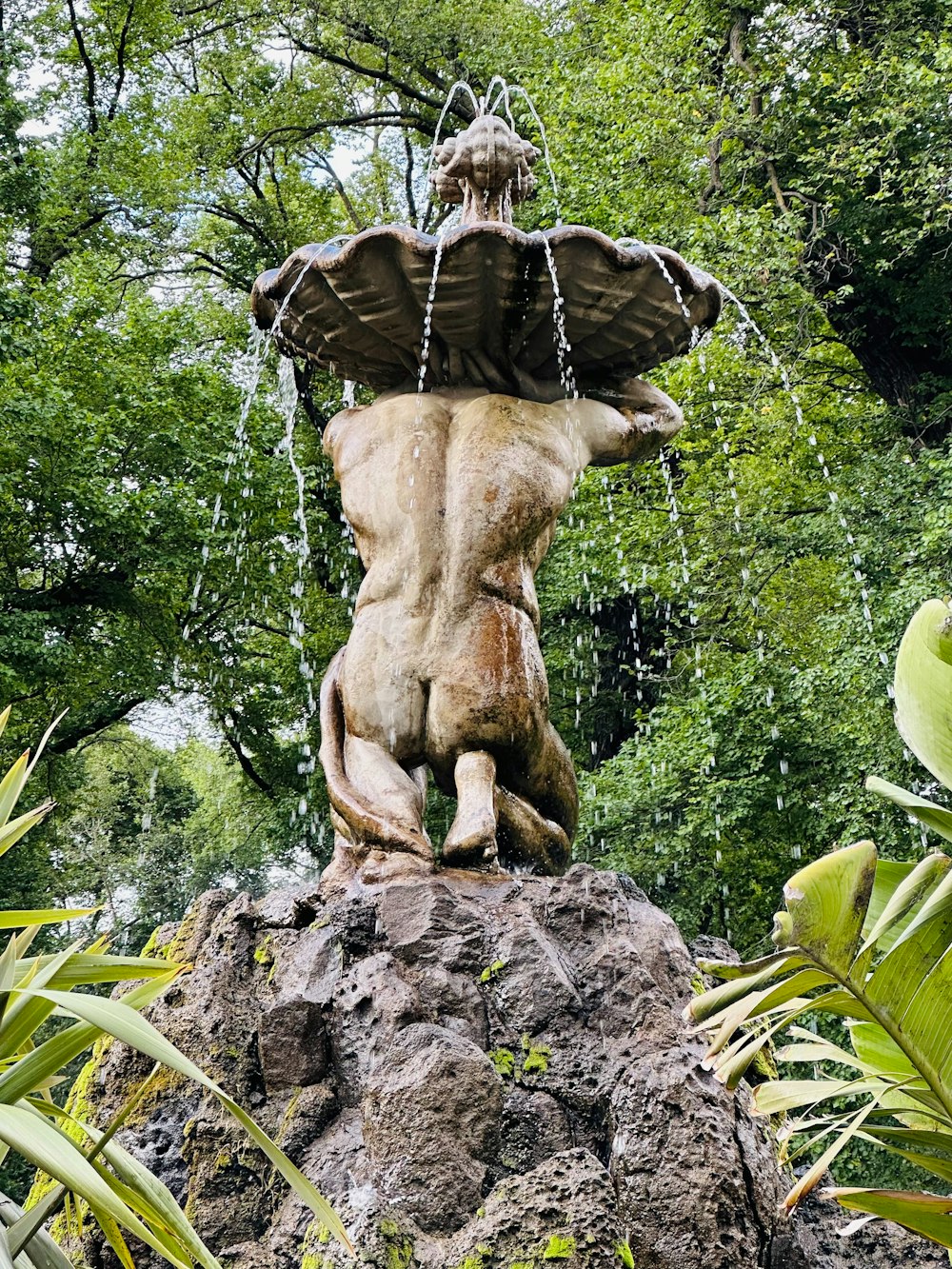 a statue of a man sitting on top of a rock