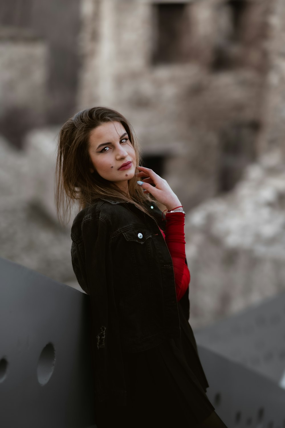 a woman leaning against a wall talking on a cell phone