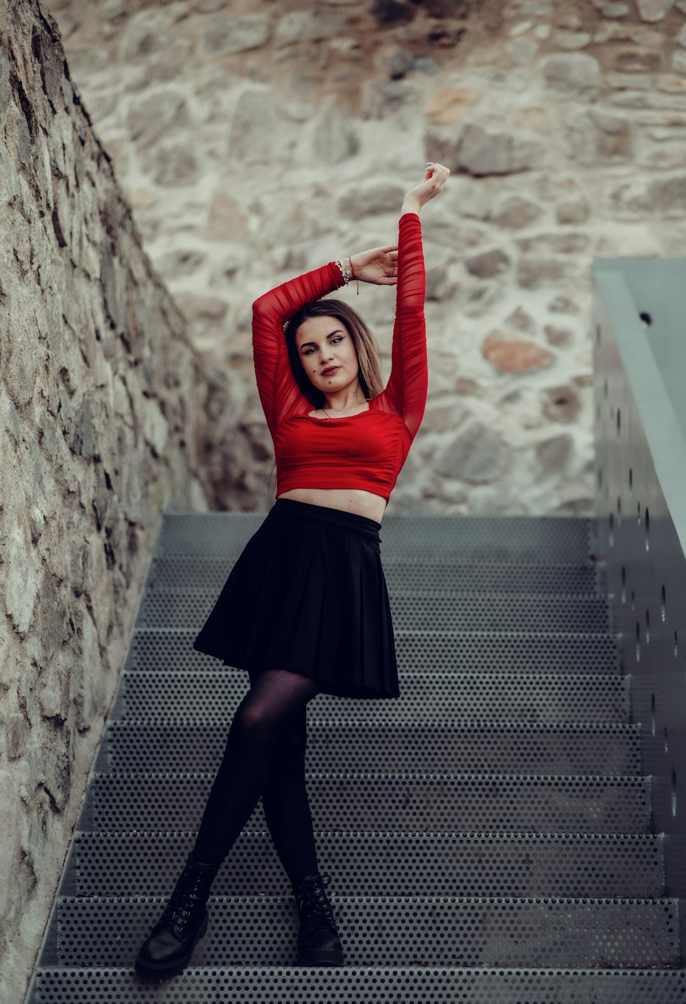 a woman in a red top and black skirt