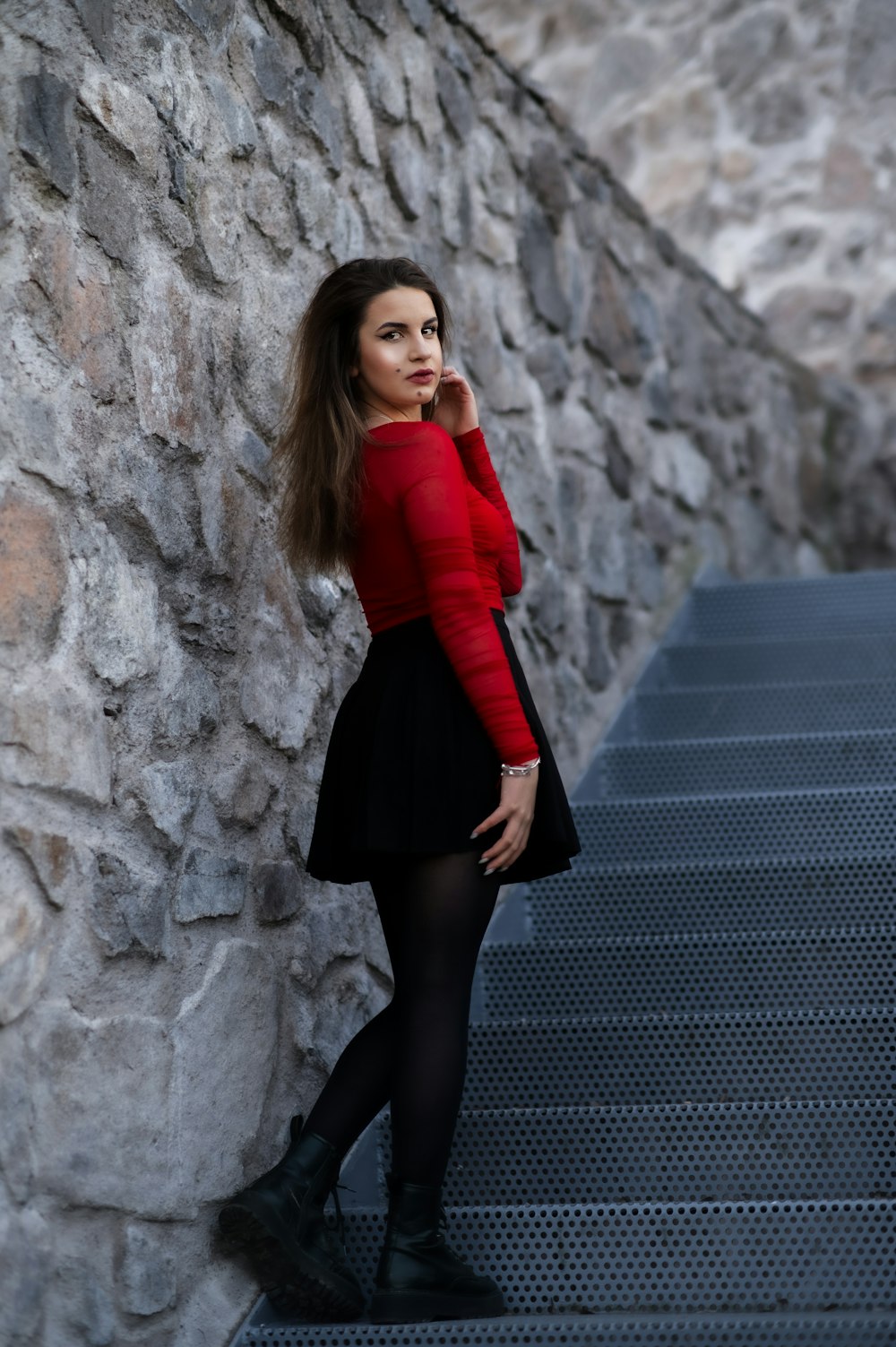 a woman in a red shirt and black skirt