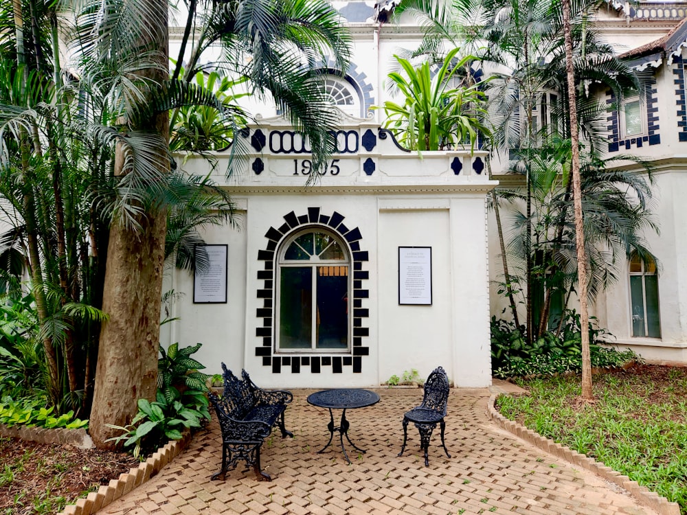 a patio with a table and chairs in front of a building