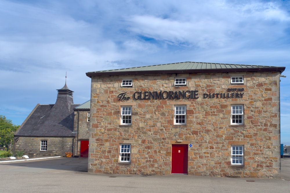 a stone building with a red door and windows