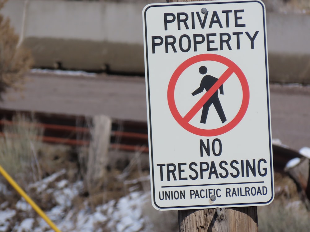 a no trespassing sign on a wooden post