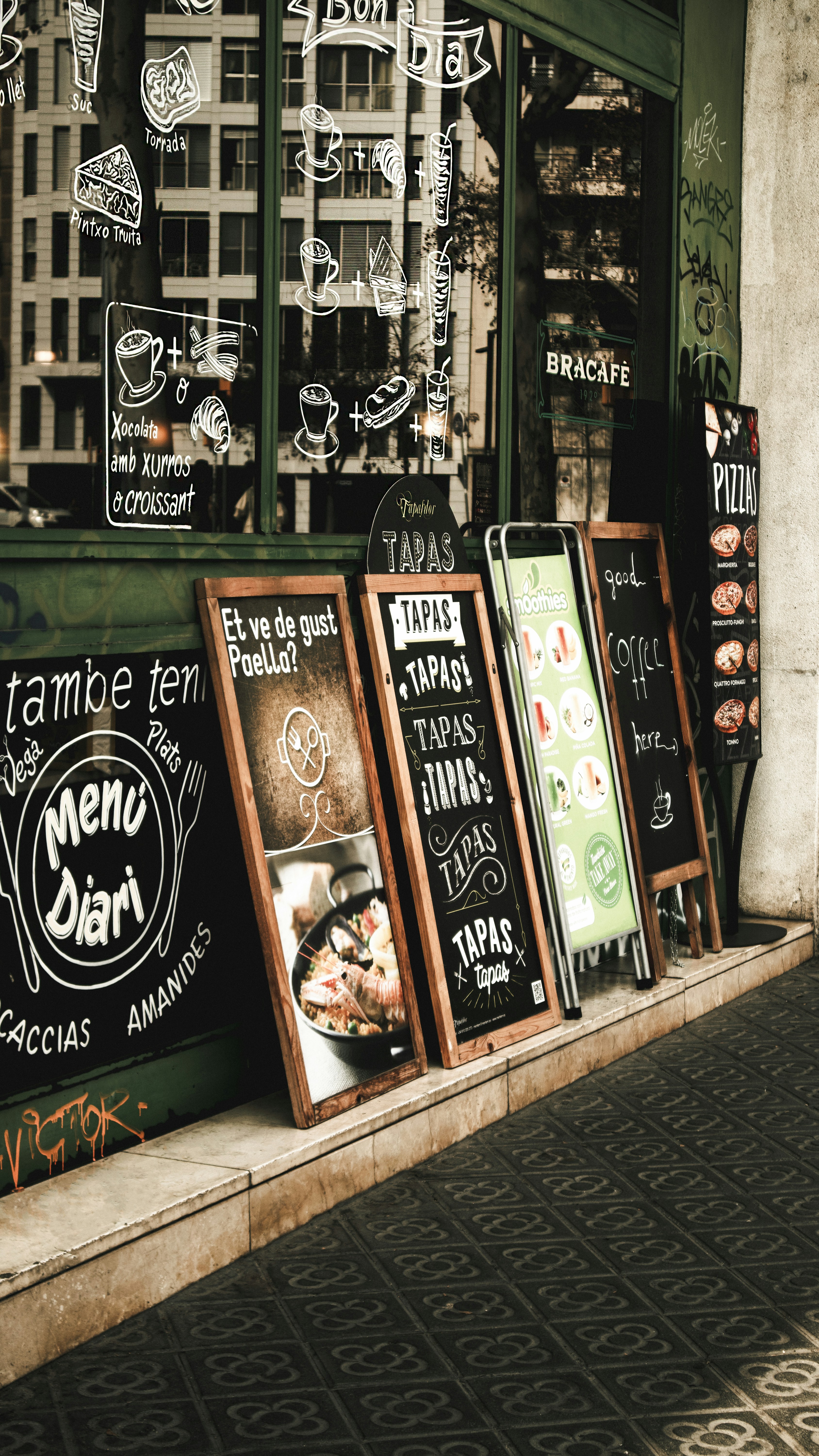 una fila di tabelloni dei menu seduti sul lato di un edificio