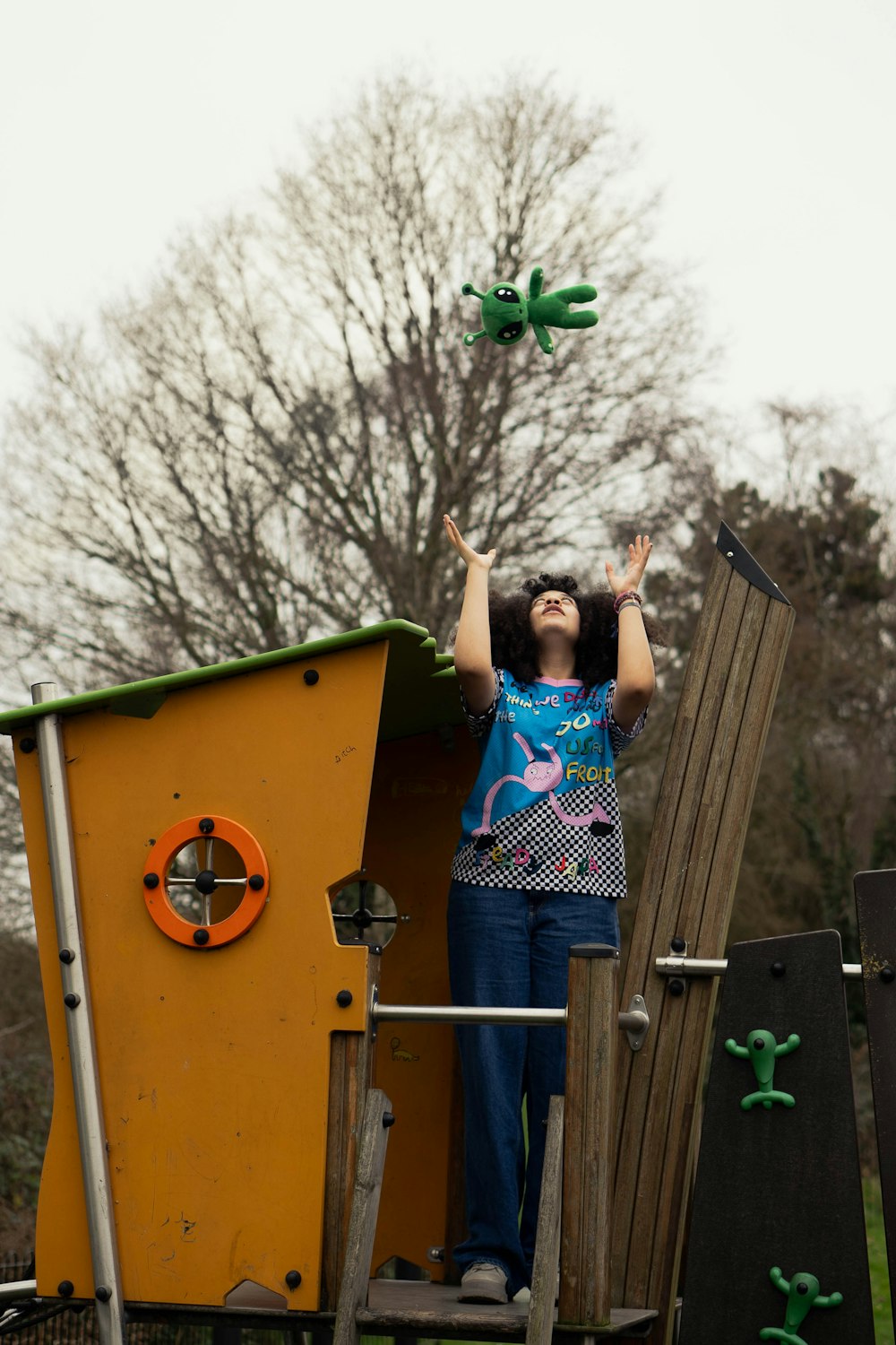 a woman standing on top of a wooden slide