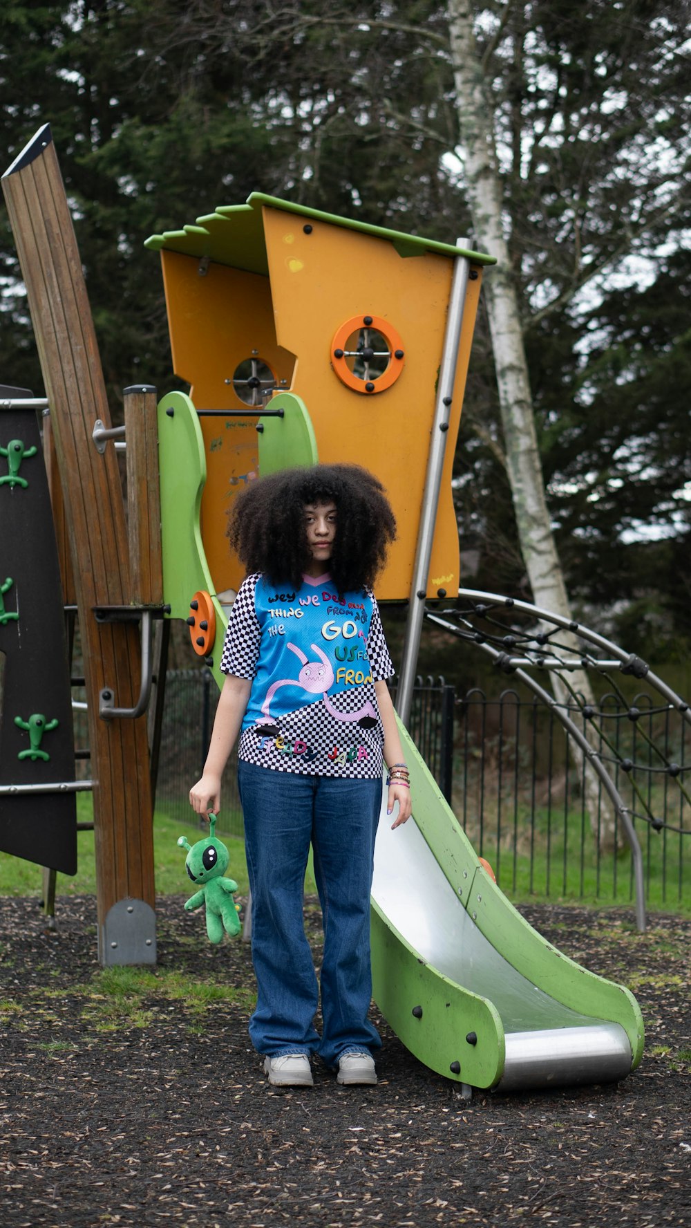 a woman standing next to a green slide