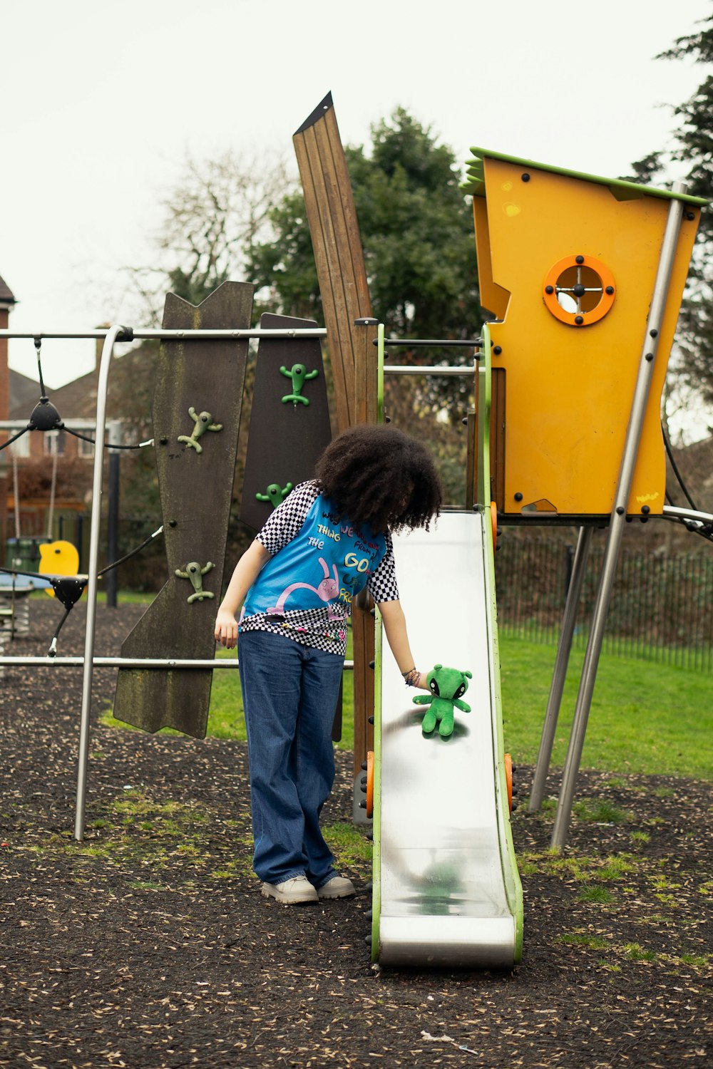 a little girl standing next to a slide