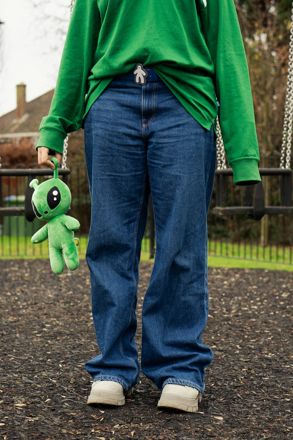 a person in a green shirt holding a green stuffed animal