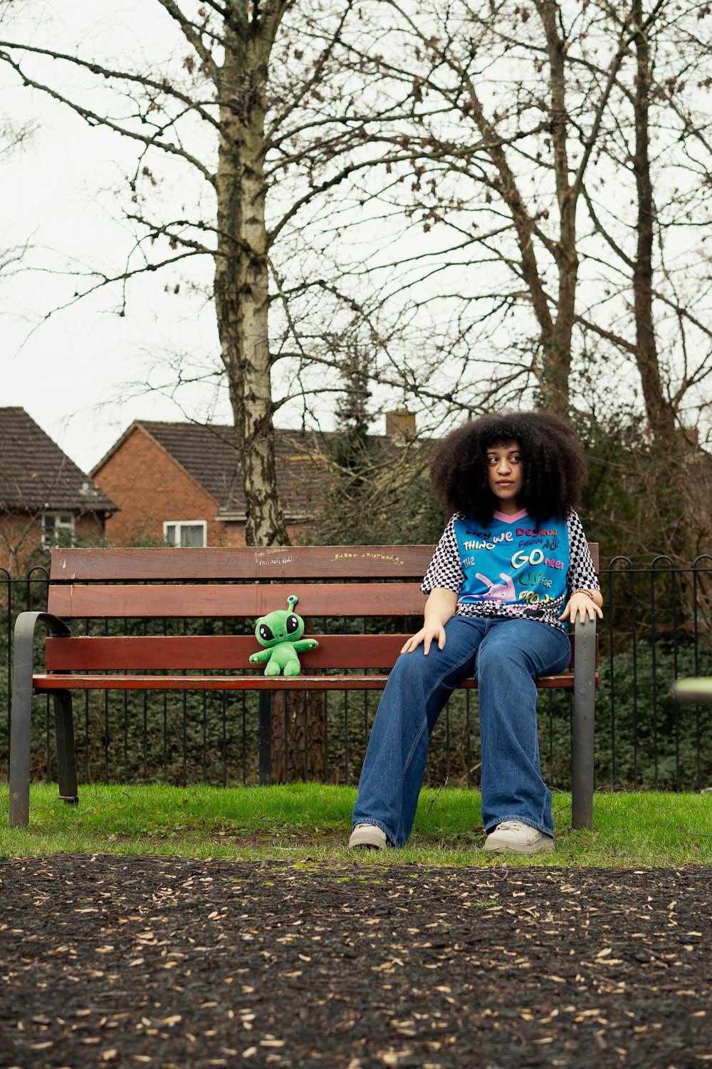 a woman sitting on a park bench with an afro on her head
