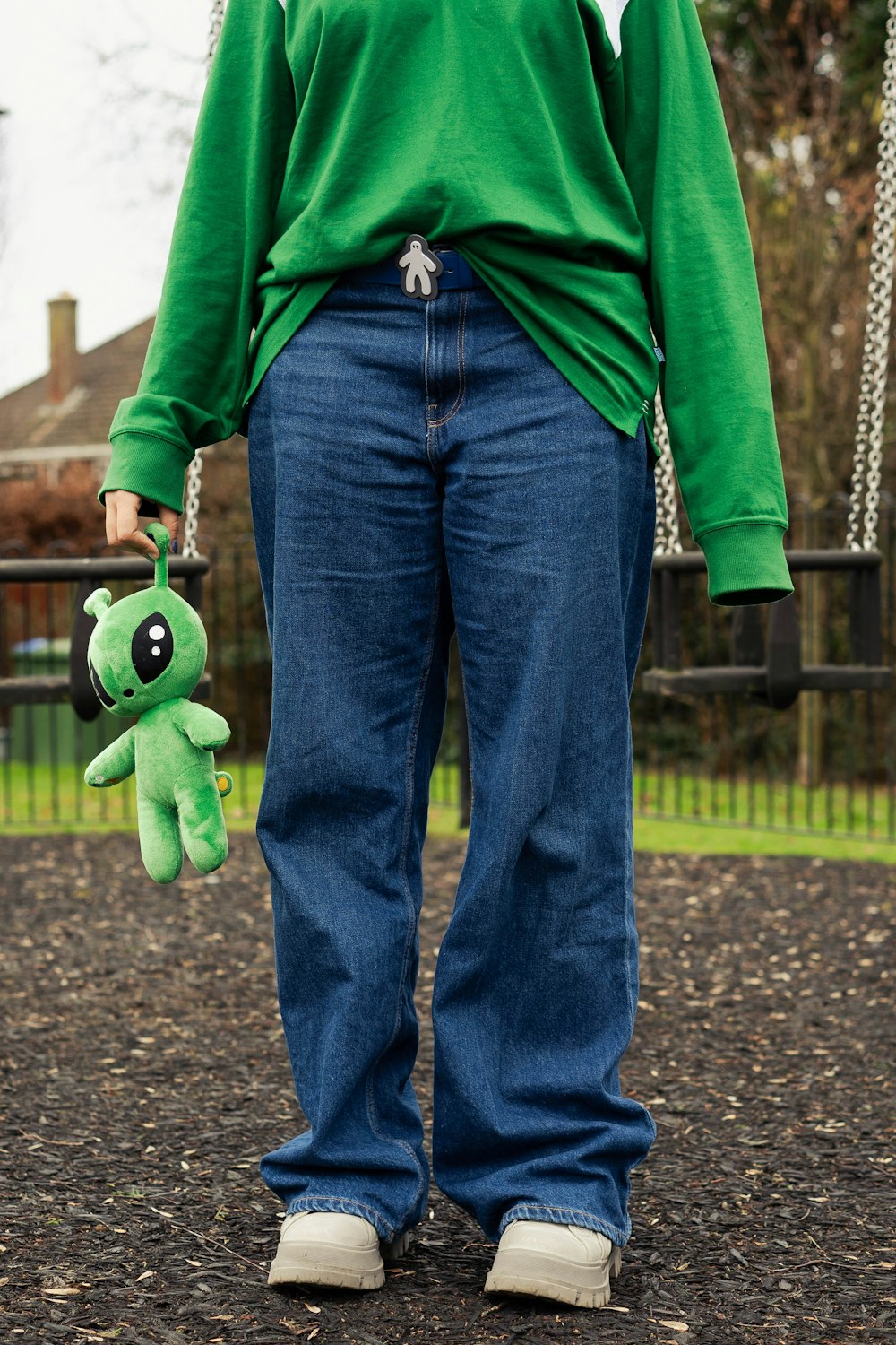 a person in a green shirt holding a green stuffed animal