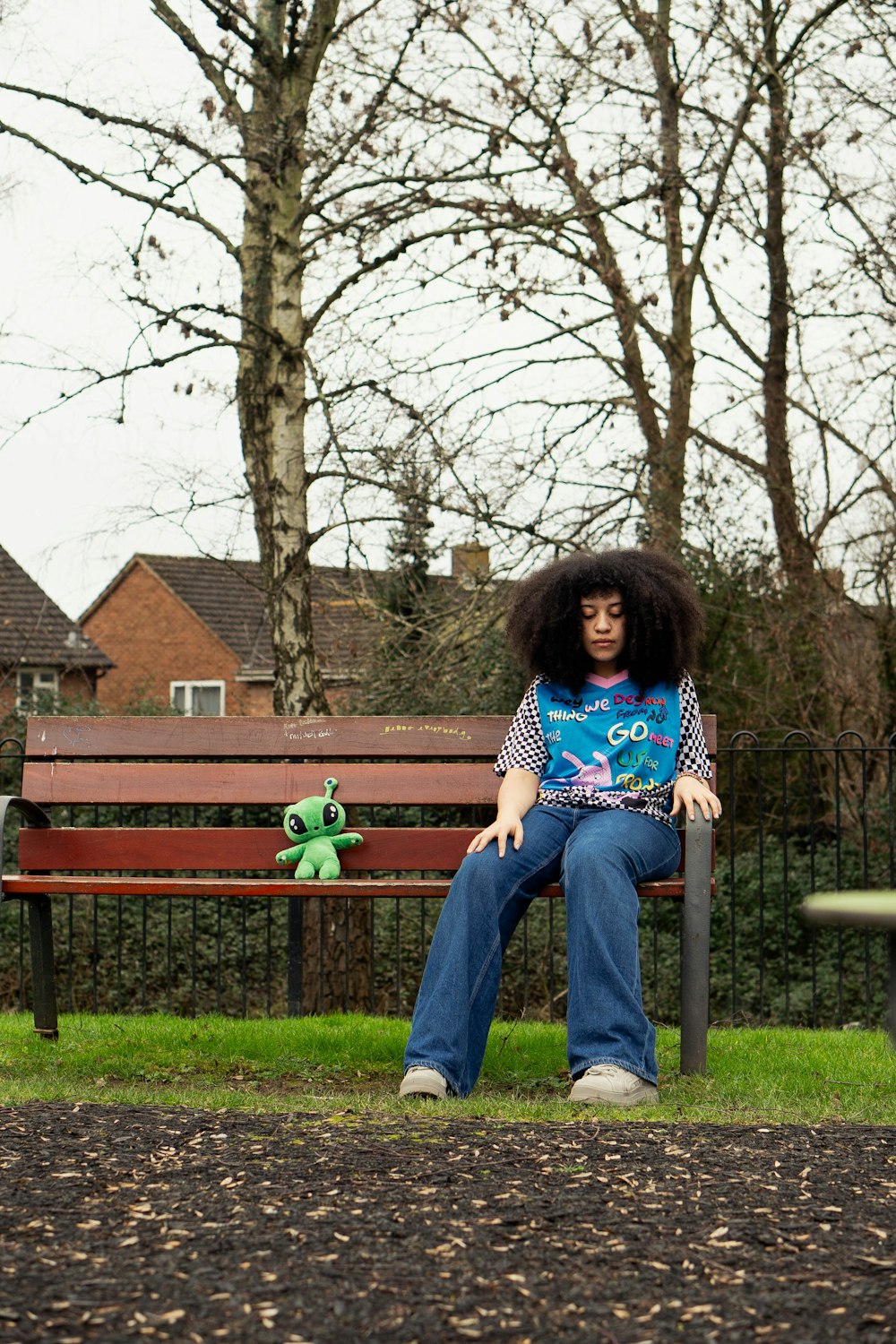 a person sitting on a bench in a park