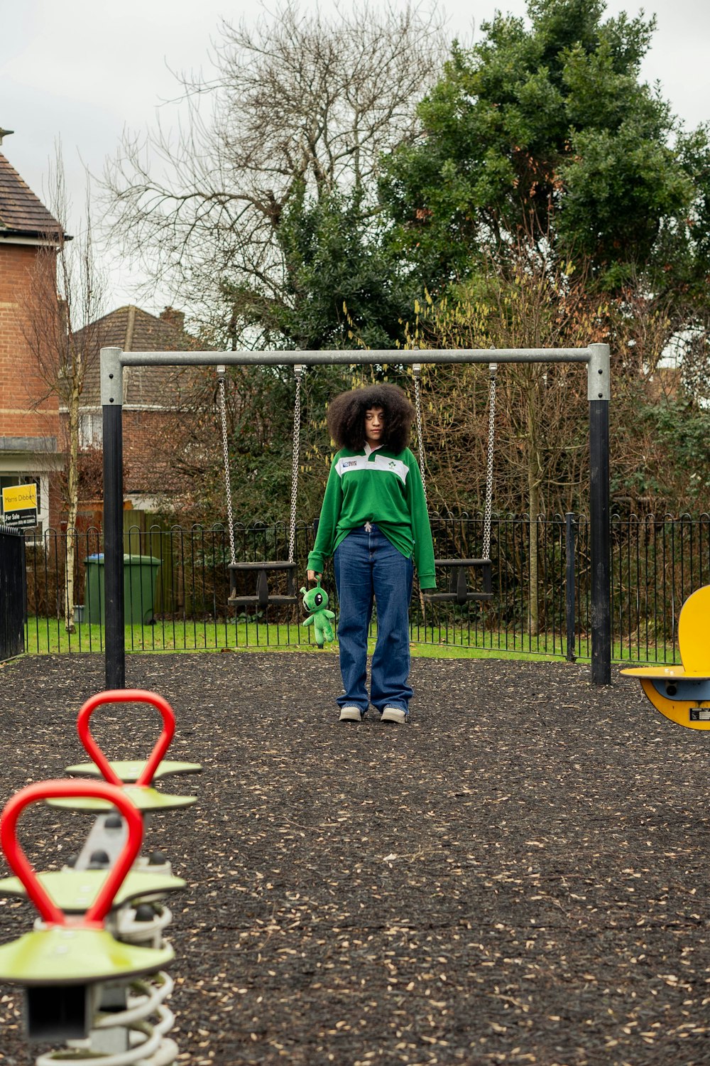 a young child standing in front of a playground