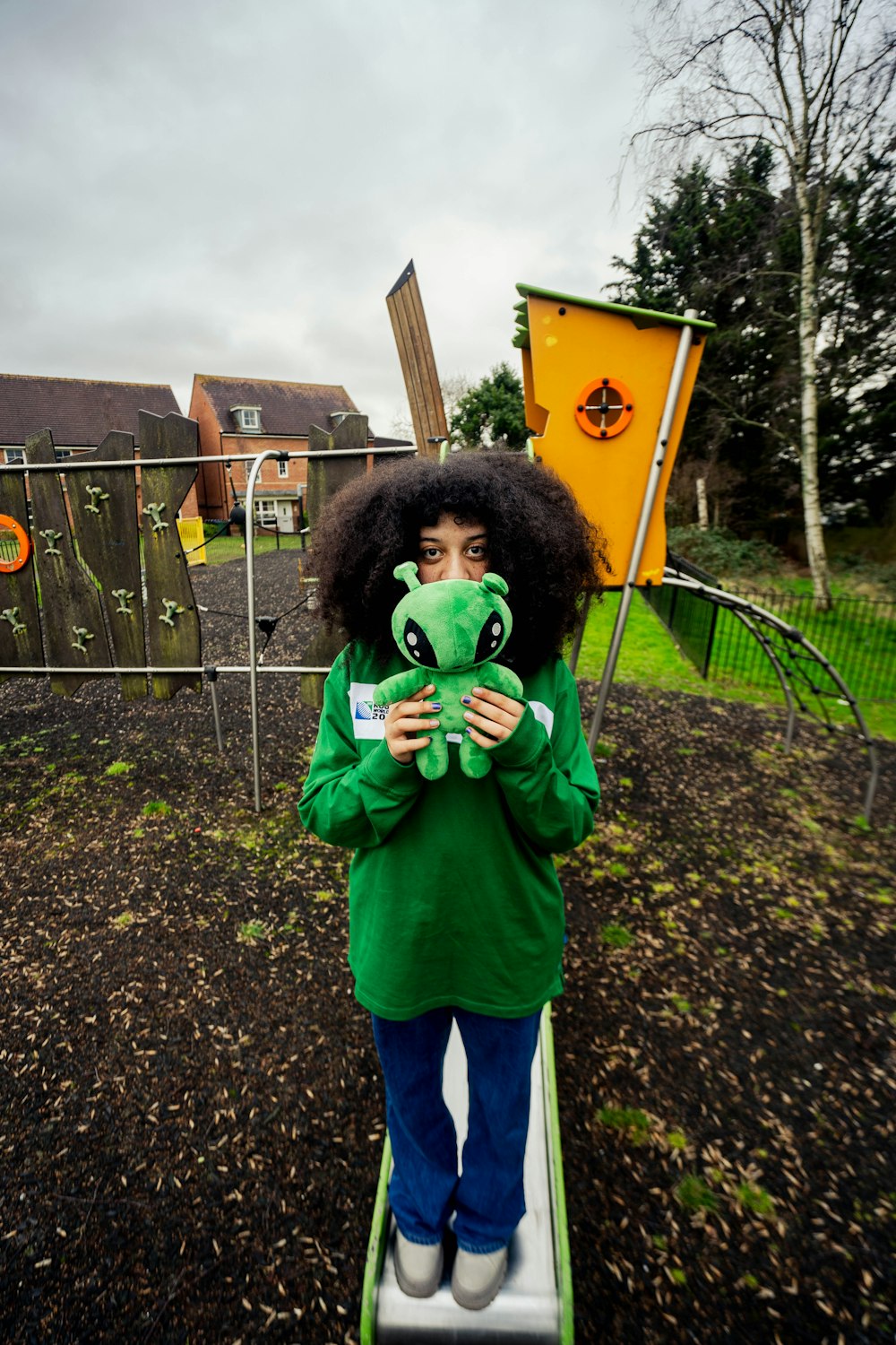 a woman in a green shirt holding a stuffed animal