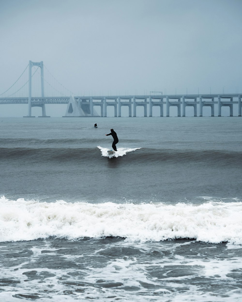 a man riding a wave on top of a surfboard