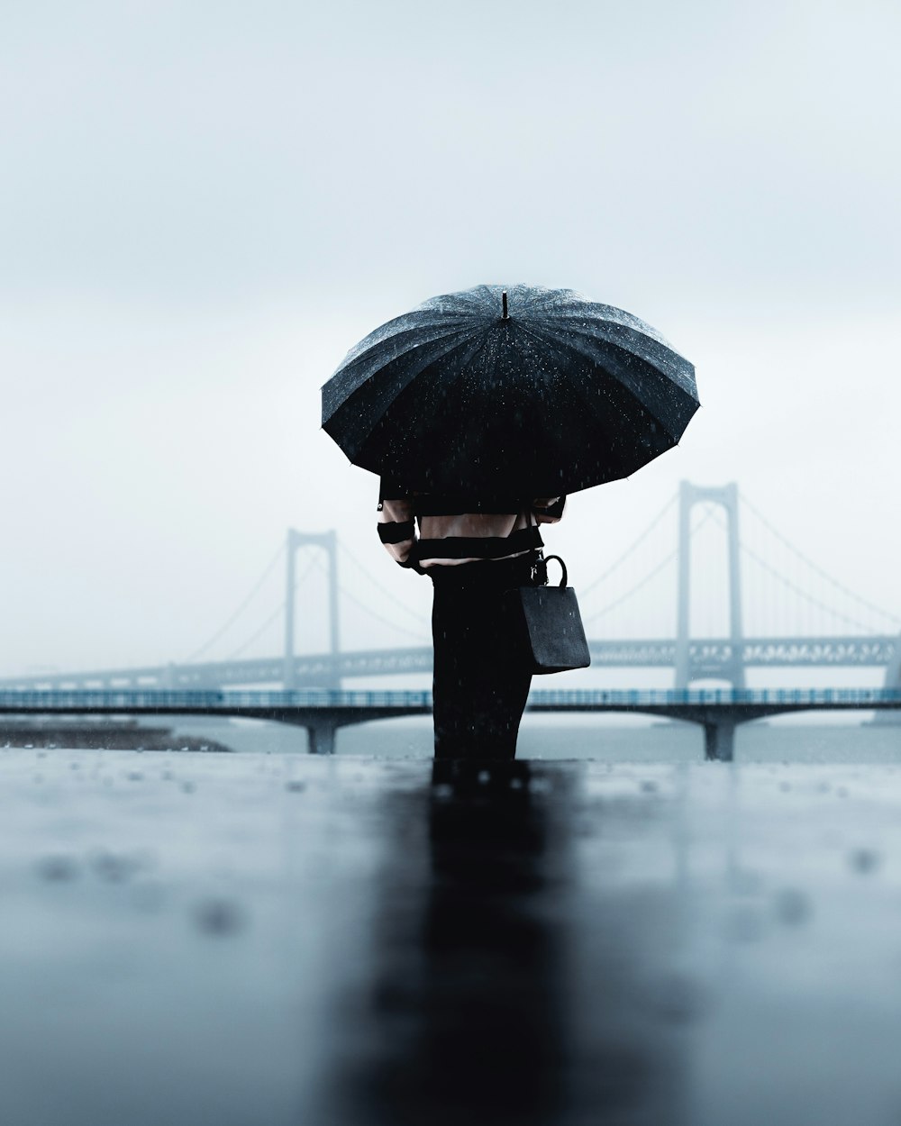 雨の中、傘をさす人