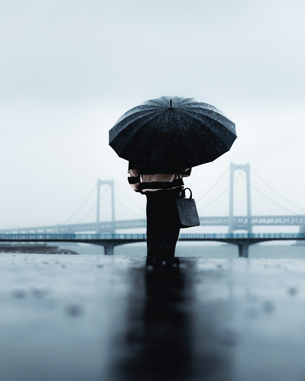 a person holding an umbrella in the rain