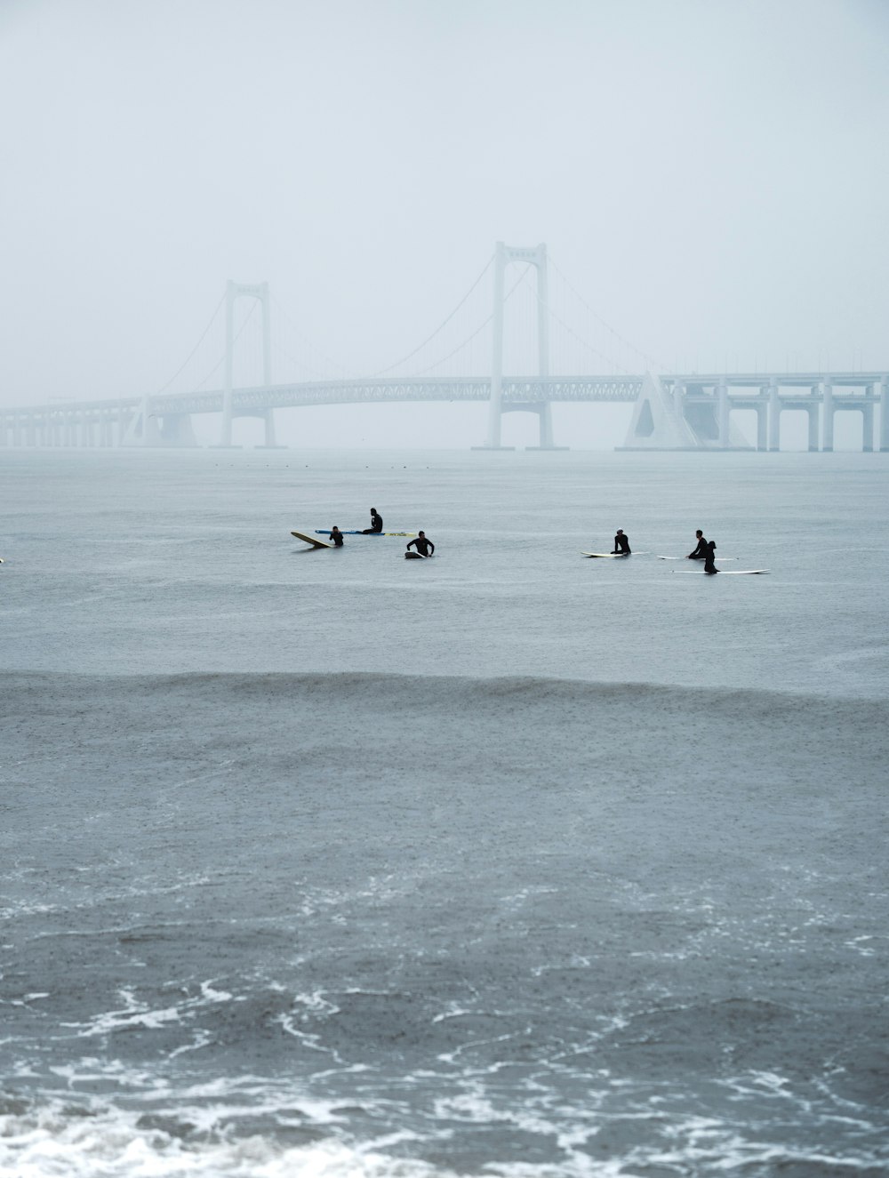 a group of people riding surfboards on top of a body of water