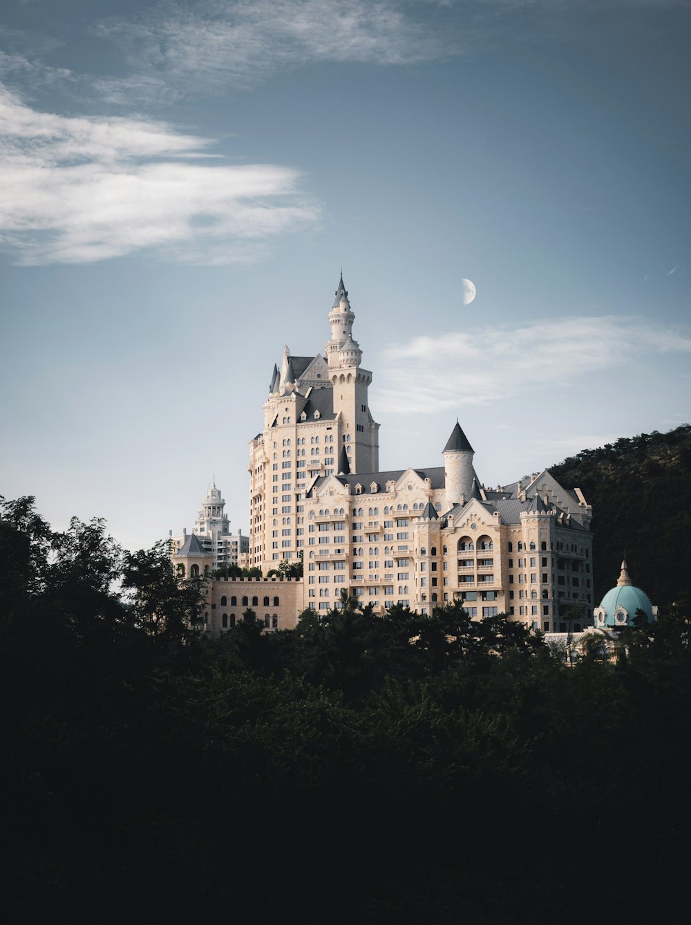 a large building sitting on top of a lush green hillside