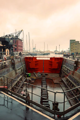 a boat dock with a red wall and stairs