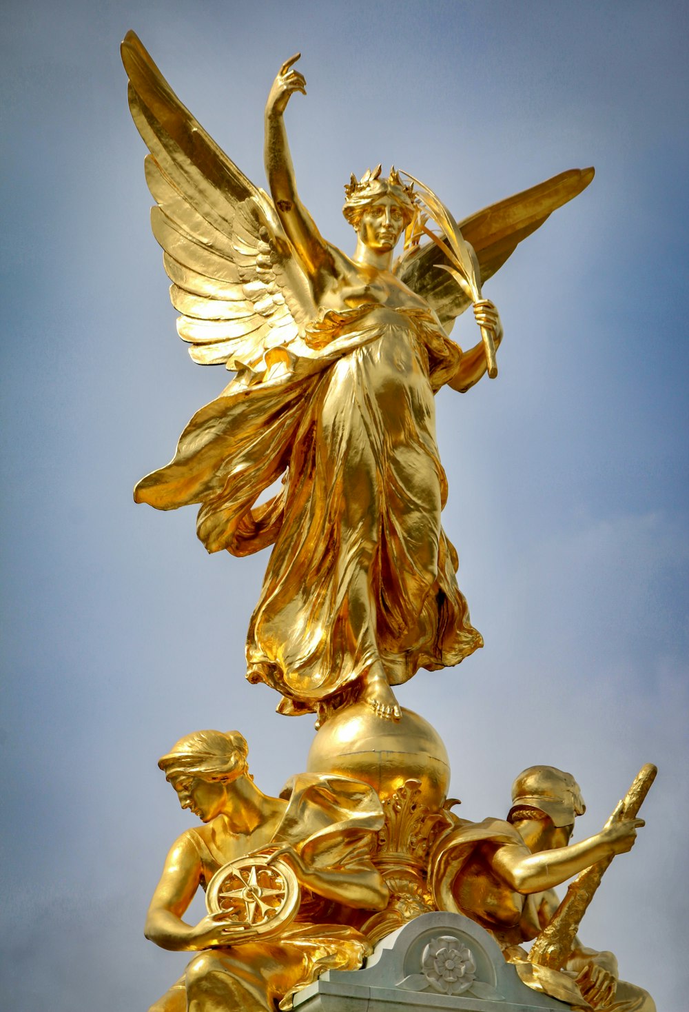 a gold statue of an angel on top of a building