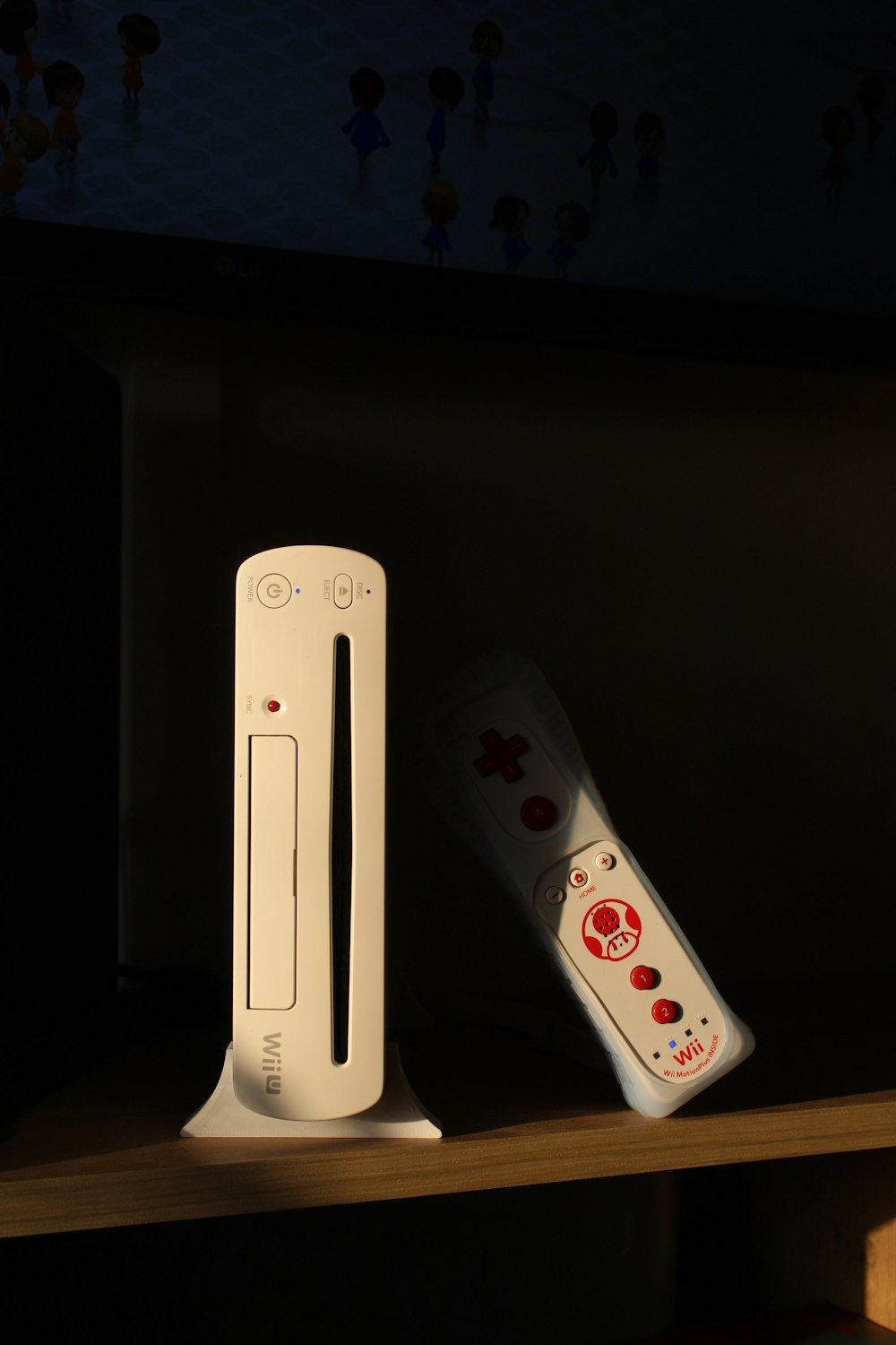 two nintendo wii game controllers sitting on a shelf