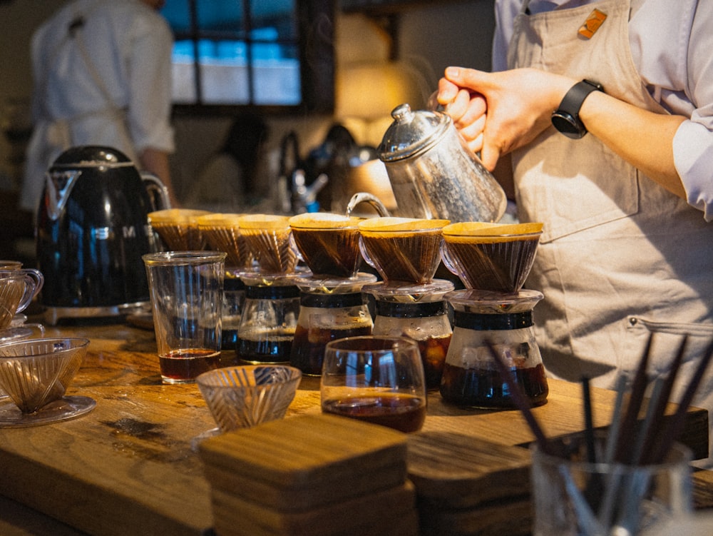 eine Person, die eine Tasse Tee auf einen Holztisch gießt