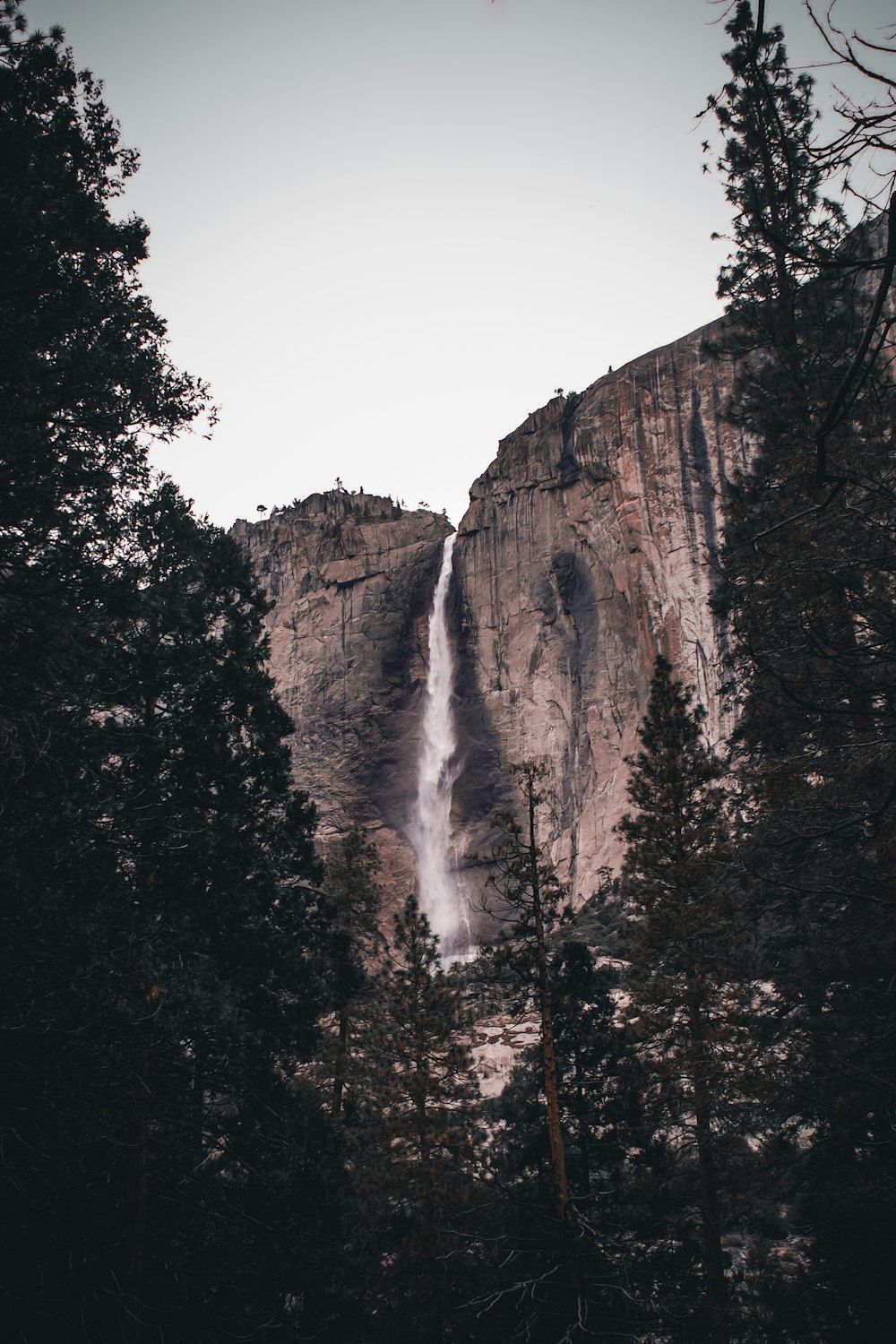 a waterfall is seen from the bottom of a mountain