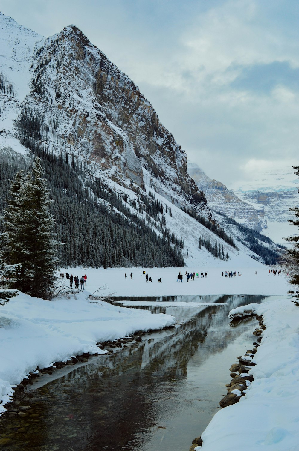 a group of people walking across a snow covered mountain