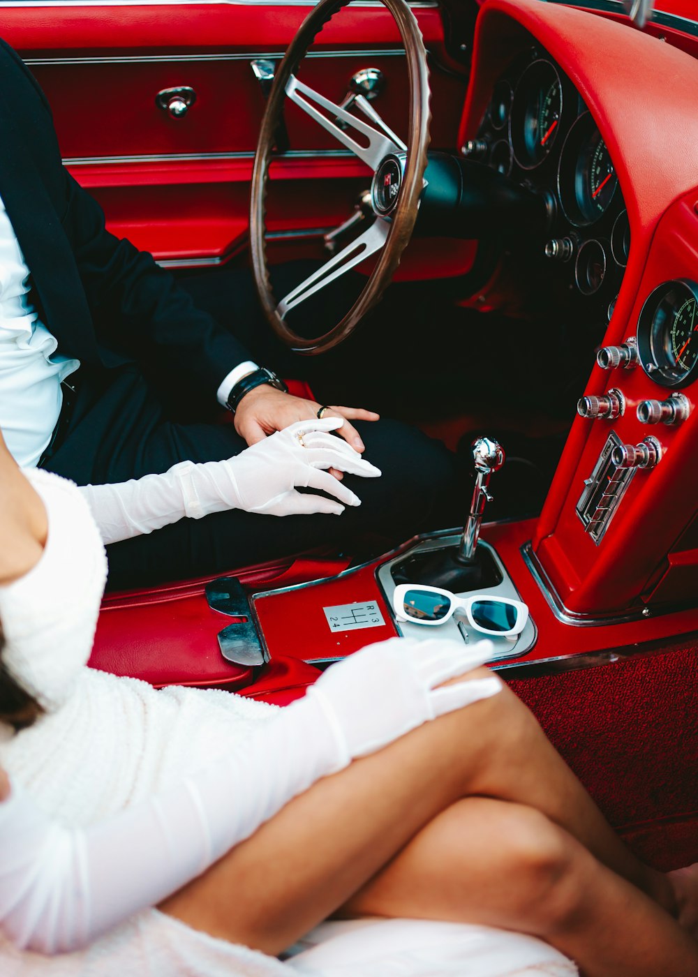 a man and a woman sitting in a red car