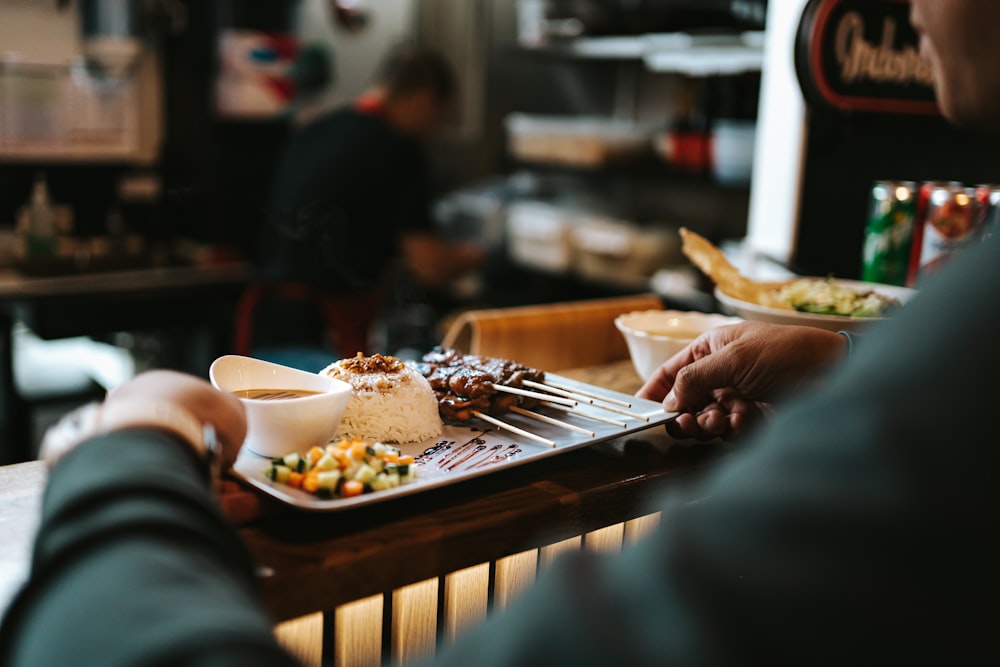 a person sitting at a table with a plate of food