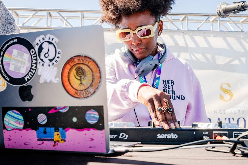 a woman wearing sunglasses is using a laptop