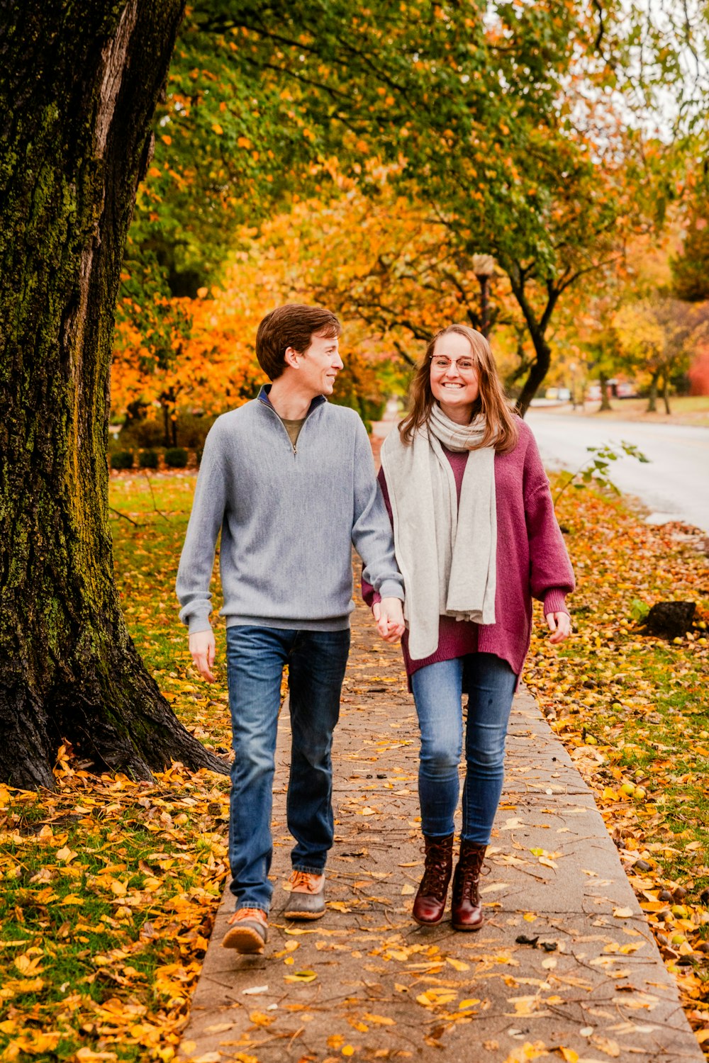 a man and a woman walking down a sidewalk holding hands