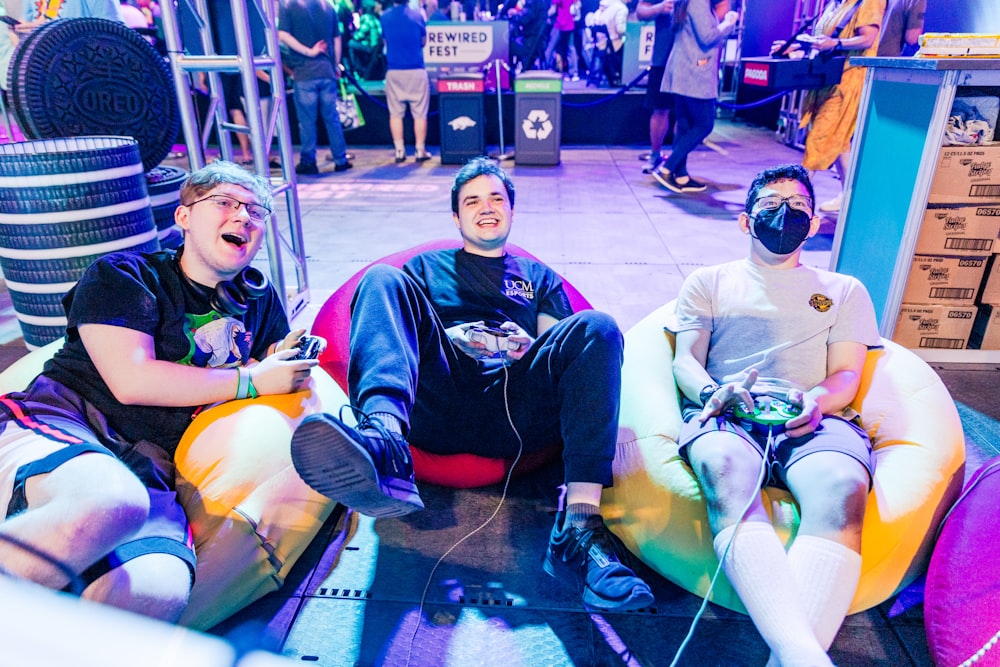 a group of men sitting on top of bean bag chairs