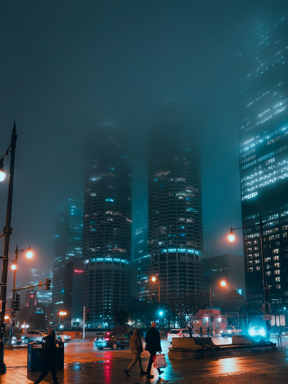 people walking in the rain in a city at night