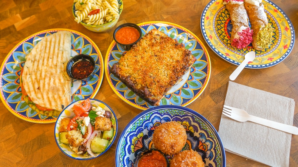 a wooden table topped with plates of food