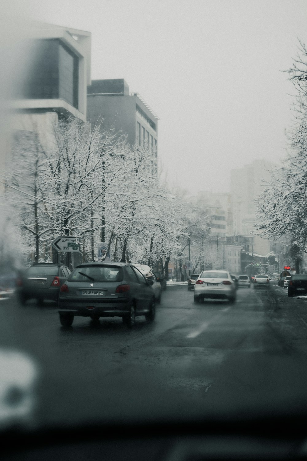 a city street filled with lots of traffic next to tall buildings