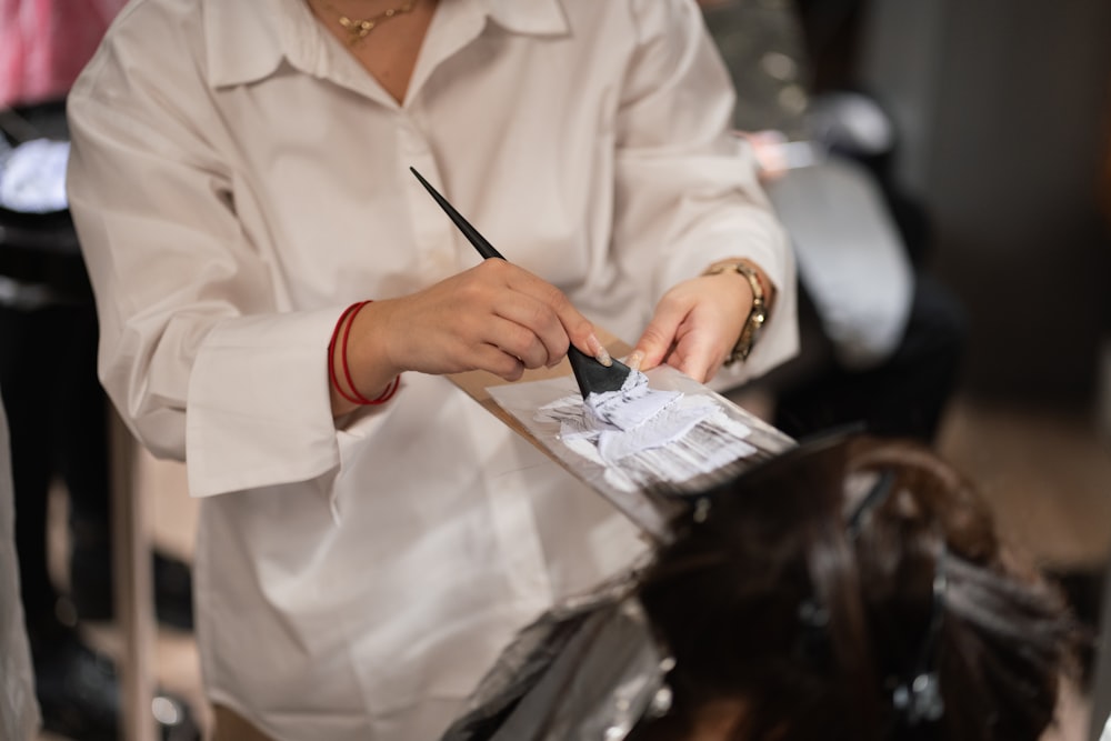 a woman cutting another woman's hair with a pair of scissors