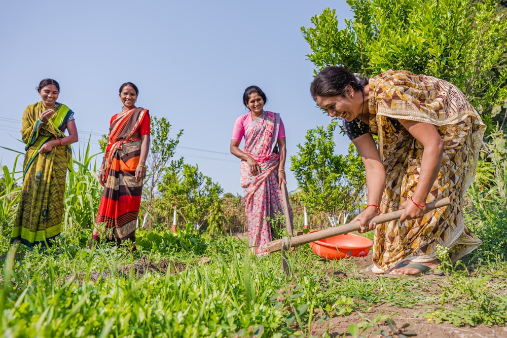 a group of women standing next to each other in a field