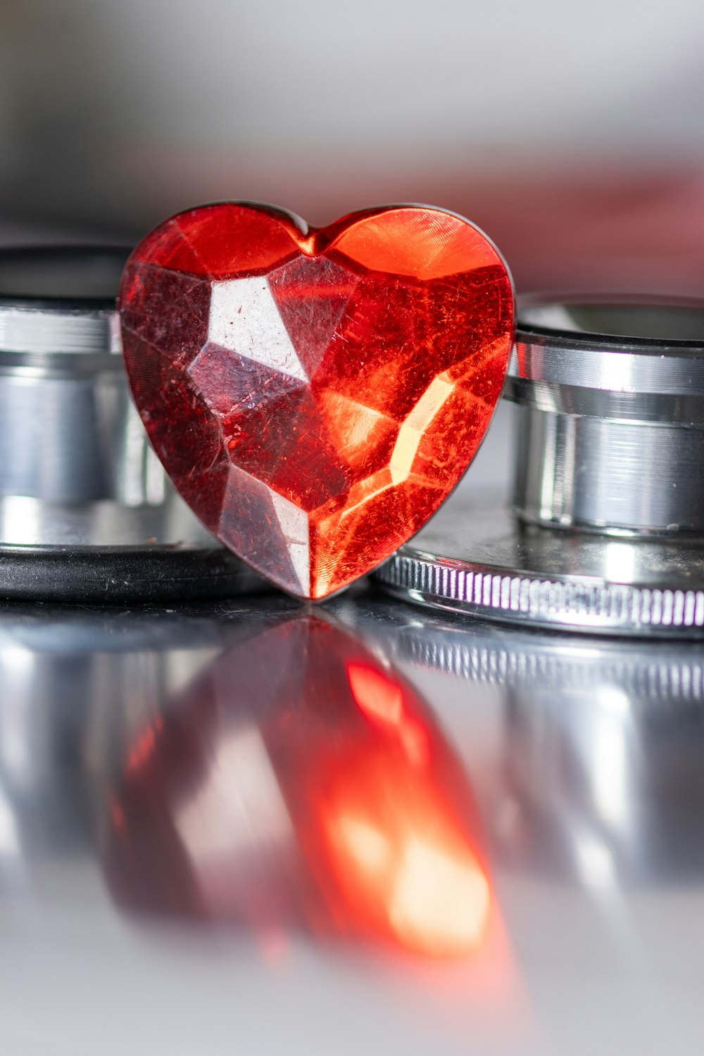 a red heart shaped diamond sitting on top of a stethoscope