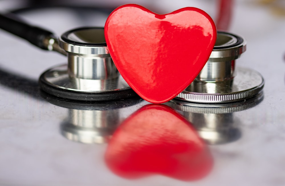 a red heart sitting on top of a stethoscope