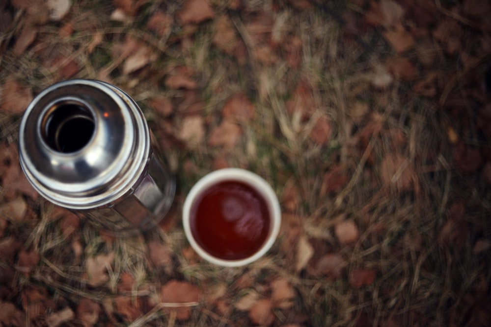 a cup of tea sitting on top of a grass covered field