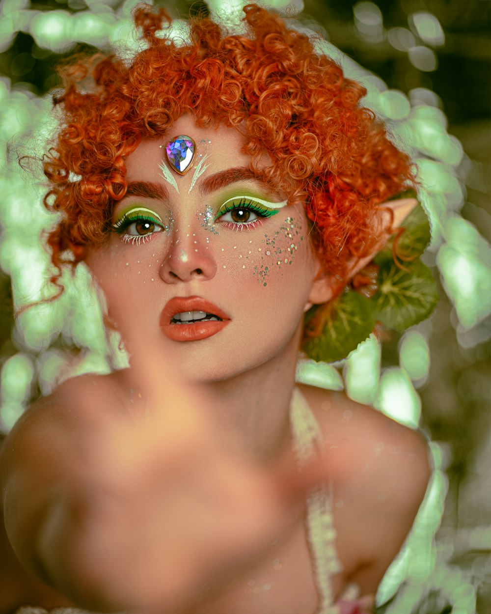 a woman with red hair and green makeup