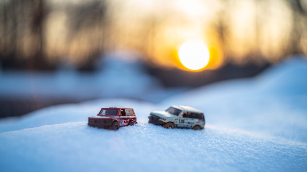 two toy cars are sitting in the snow